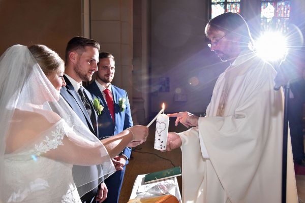 Brautpaar entz�ndet Hochzeitskerze in einer Kirche