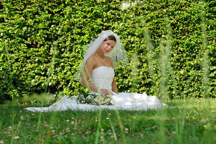 Braut sitzend auf einem Rasen