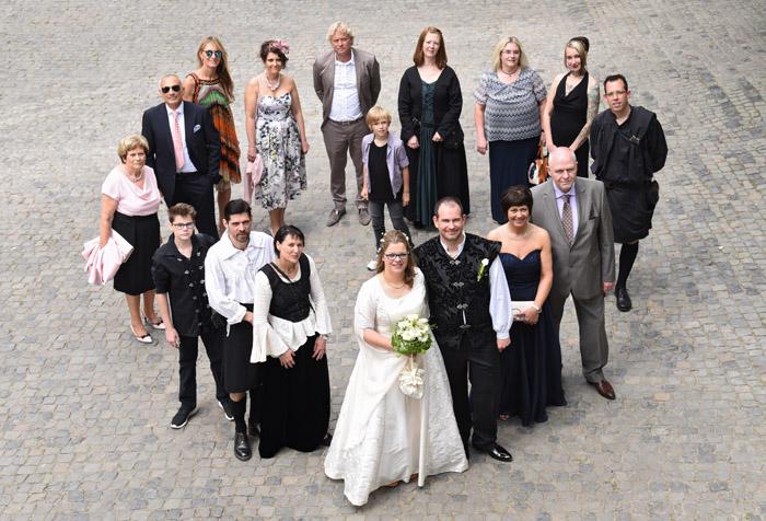 Gruppenfoto in Herzform mit Brautpaar und Gästen